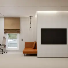 Nowoczesne wnętrze z biurkiem, sofą i telewizorem.